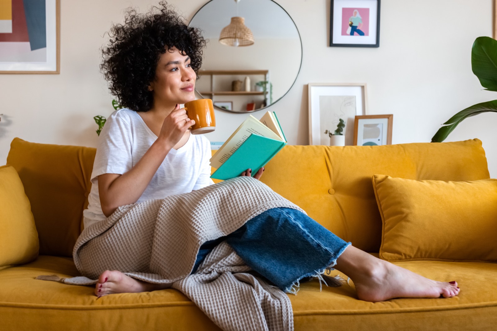 A reader relaxing at home with a book and coffee